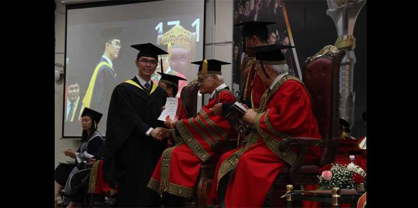 邱建违(左) 从UCSI大学名誉校长丹斯里阿都拉曼阿尔斯哈手中接过2019年“优秀毕业生奖”。
